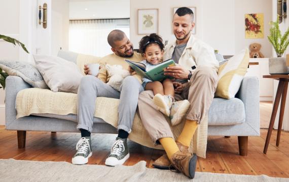 dads and child reading a book together during banned books week