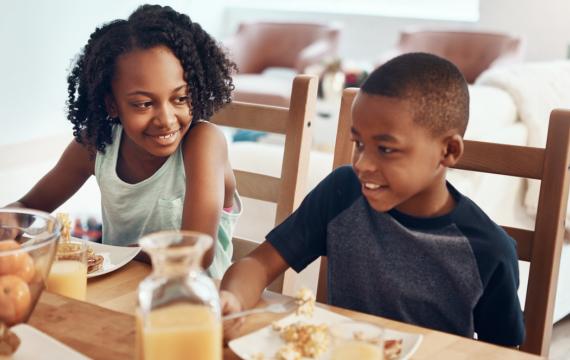 Two siblings eating breakfast together