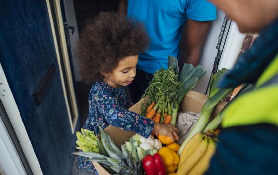 child checks out a bountiful CSA box