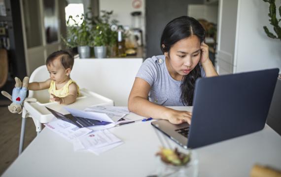 overwhelmed young mom trying to work from home while caring for a baby