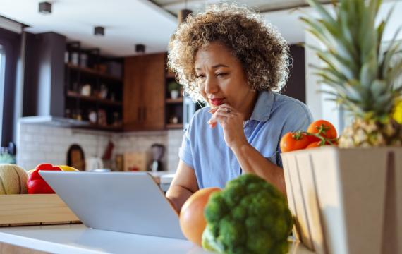 Woman sitting in front of a laptop ordering groceries online