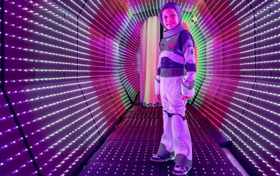 Young boy stands in the light tunnel at Cosmic Carnival in Seattle, a seasonal Halloween event for families