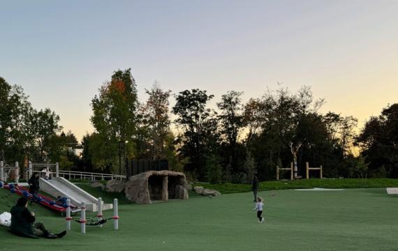 Young girl running in open space at Pathways Park, a lighted Seattle playground