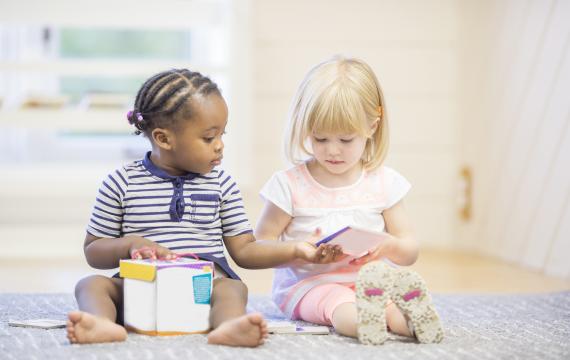 two toddlers sharing toys