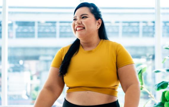 hopeful woman looks ahead to the new year in a happy yellow top