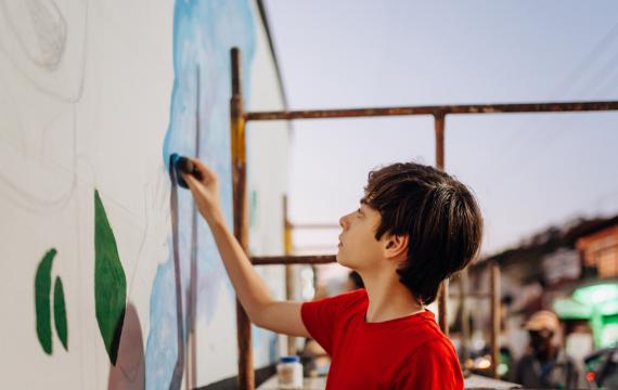 creative tween artist painting a mural