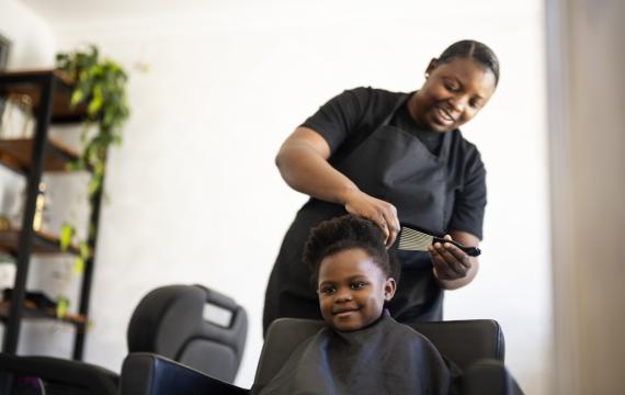 child getting her hair cut and styled in a Seattle salon that specializes in Black hair