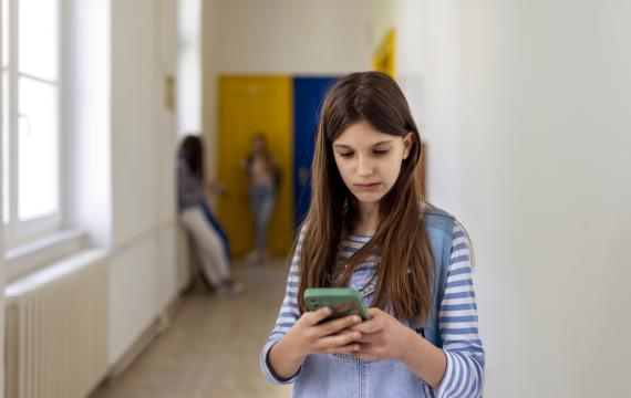 a student looks at a cell phone at school and seems unhappy