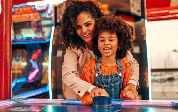 mom and daughter playing air hockey for an afternoon of retro fun in Seattle