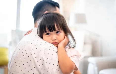Dad comforting his child who is crying because she is a kid with anxiety