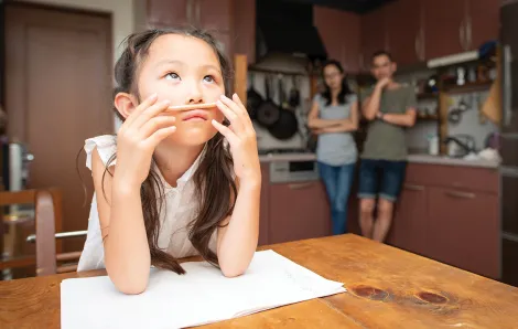 Young girl sitting at a table with homework