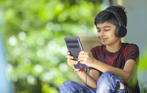 Young boy wearing headphones using an education app