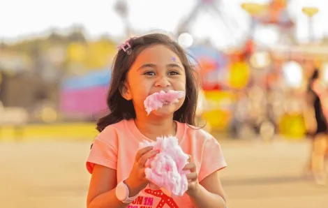 Girl eating cotton candy at the Washington sate Fair in Puyallup 