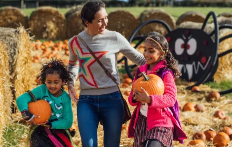 Mom and two daughters picking pumpkins at a pumpkin patch near Seattle