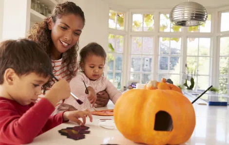 Mom and two kids having fun with Halloween crafts and activities