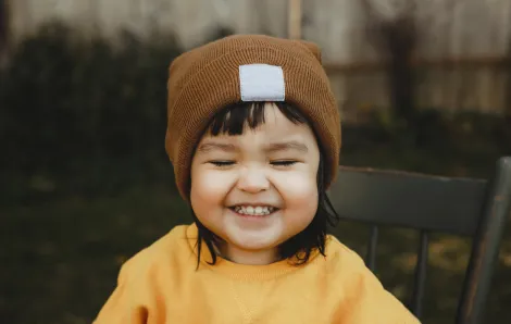 smiling toddler in fall hat and sweater