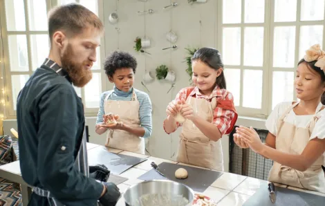 Three kids at a cooking class rolling handfuls of dough, an experience Christmas gift