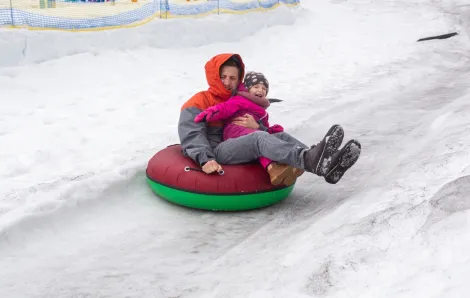 Dad and kid in a snow tube having winter fun near Seattle