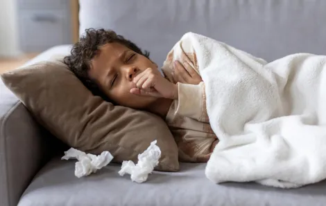 Boy resting on the couch home sick from school