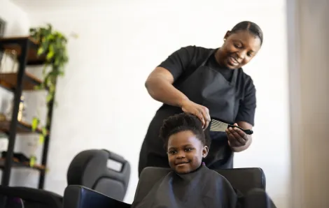 child getting her hair cut and styled in a Seattle salon that specializes in Black hair