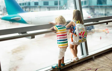 two kids looking out a window at an airplane SEA airport