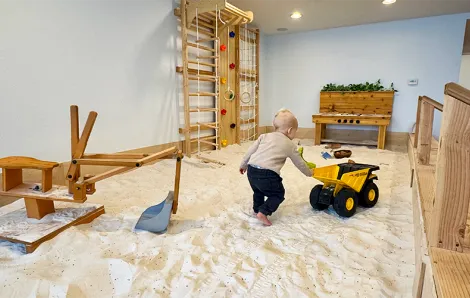 young boy pushing a truck in the lavender-scented sand pit at Wildflower Play Studio in Enumclaw