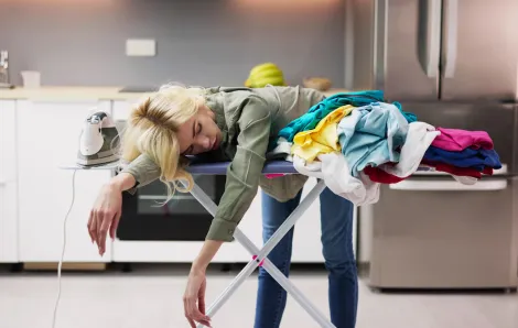 exhausted mom on laundry pile