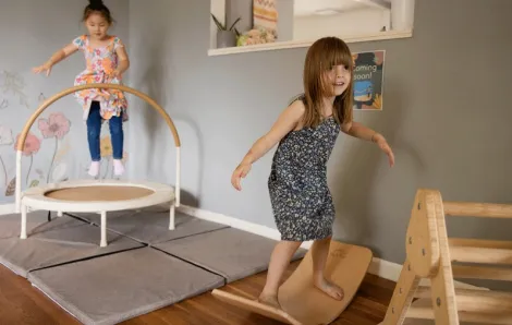 young girls jumping and balancing in an indoor play space at The Village Project in North Bend