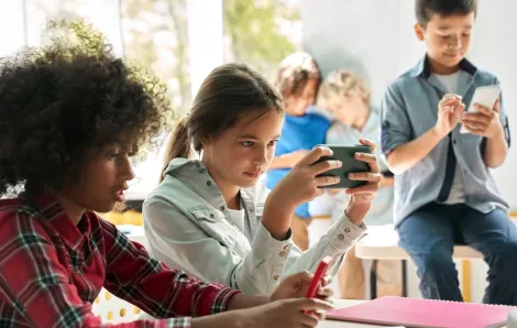 kids in a classroom not talking or doing work looking at their cell phones