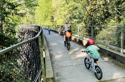 Families ride bikes over the Tokul Creek Trestle in Snoqualmie