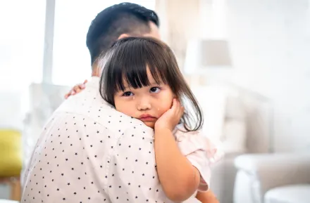 Dad comforting his child who is crying because she is a kid with anxiety