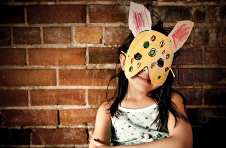 a child wears a DIY mask that she made for an indoor play activity