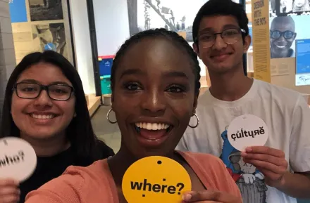 Teens hanging out holding signs in different languages at the Gates Foundation in Seattle