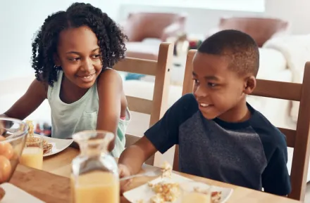 Two siblings eating breakfast together