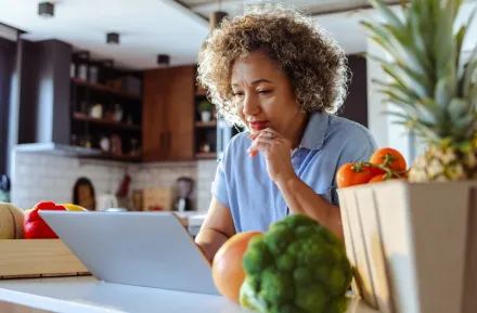 Woman sitting in front of a laptop ordering groceries online