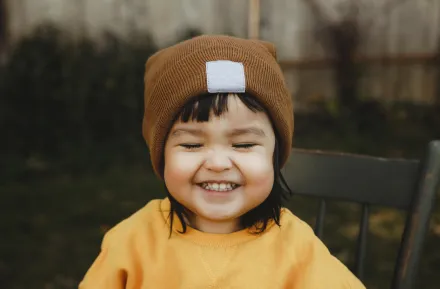 smiling toddler in fall hat and sweater