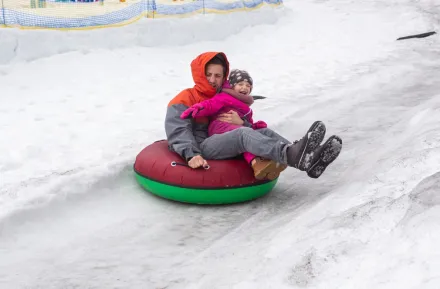 Dad and kid in a snow tube having winter fun near Seattle