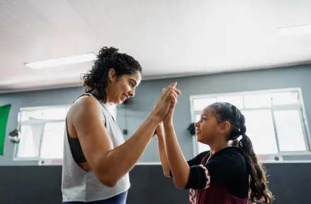 proud mom with tween daughter in a boxing gym