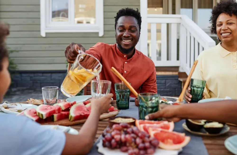 family sitting around a table eating healthy in the summer