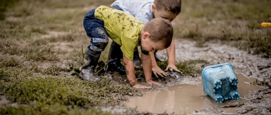 Two boys playing in the mud KidsQuest museum Bellevue