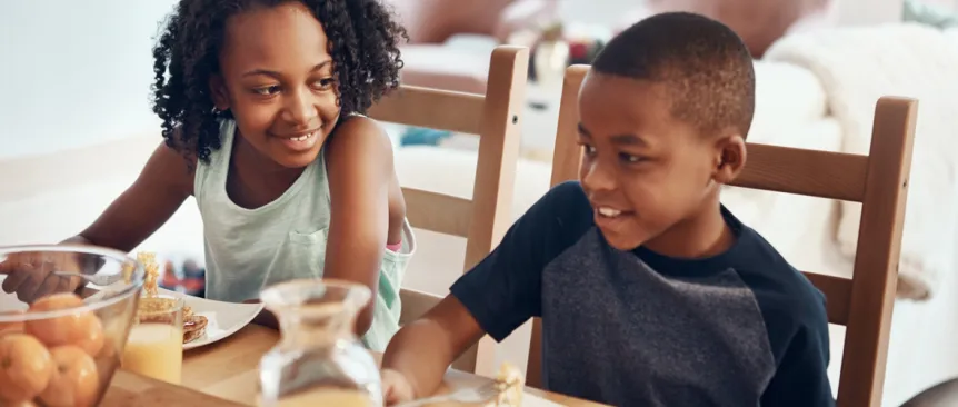 Two siblings eating breakfast together