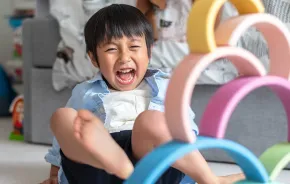 Boy playing with stacking wooden educational toy for preschoolers