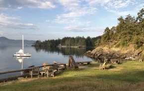 Sailboat in the bay near grassy shoreline at Doe Bay