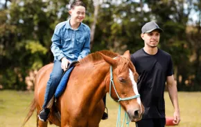 Boy riding a horse at farm animal summer camp in Seattle