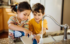 two responsible kids helping with chores by doing the dishes