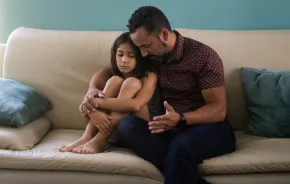 Dad and daughter talking on a couch
