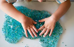 a child pays with DIY glitter slime from a birthday goody bag