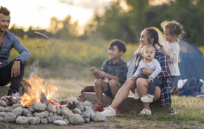 family camping with young children and sitting around a camp fire 