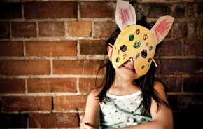 a child wears a DIY mask that she made for an indoor play activity