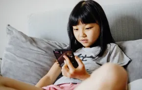 young girl looking at a smart phone using social media